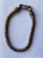 Clear photo of the sterling silver bracelet laid flat on a white background showing the box-style rounded links and hook clasp with decorative ridges.