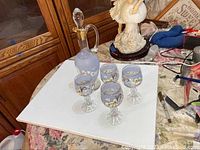 Full set showing one pitcher and four goblets on white surface.