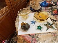 Overview of lot showing all items including the yellow glass vase, amber Venetian bowl, perfume sprayer, and three glass starfish