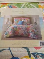 Packaging label showing Oceanfront Resort King Quilt Set with dimensions and floral bedding photo