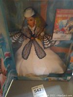Barbie doll in white and black period gown inside original box with promotional text visible on the right side.