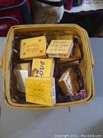 Basket containing various wooden craft stamps with designs of Mickey and Minnie, hearts, florals, sunshine, and love-themed text.