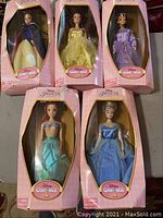 Five Disney Princess Classics collectible dolls, visible in original pink packaging with clear front windows.