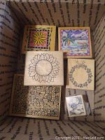 Top view of several wooden craft stamps with floral and colorful designs inside a box.