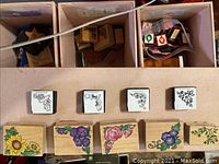 Craft stamps with floral designs and colored flower images on the sides, showing detailed rubber stamp patterns on wooden blocks.