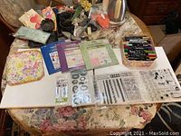 Lot of art supplies laid out on table, including markers, stamps, and brush holders.