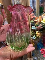 Close-up photo of the green and pink fluted glass vase with rippled design.