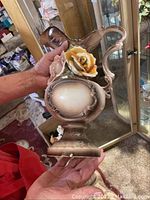 Full view of the Capodimonte porcelain pitcher held by a person showing side and floral details.