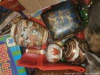 Photo showing five items: hand painted ceramic vase, decorative trinket box, two salt and pepper shakers, round ceramic vase with traditional pattern