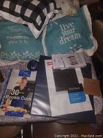 Photo of 30 Minute Rookie Cook cookbook, black binder, and new ear cleaning kit pieces in sealed plastic case.