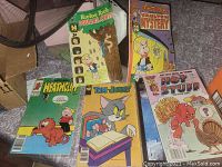 Group photo of five vintage comic books from different cartoon series shown on a surface