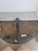 U-Haul trailer hitch laying on a welcome mat, showing the full hitch shape and mounting holes.