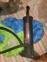 Photo of the Double Quick hand pump laying on colorful fabric with a hose attached, showing branding and overall condition.