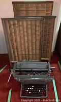 Front view showing typewriter and three trays stacked behind