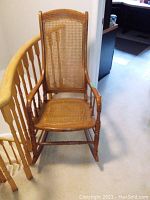 Front view of rocking chair showing full shape, wood frame, wicker seat and back