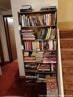 Six-shelf bookcase filled with dozens of rock and Beatles books