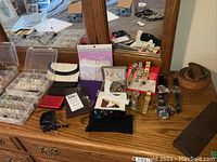 Dresser top displaying multiple clear organizer boxes of jewelry, coin purse, sunglasses, belt and watches