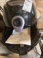 Photo of Avalon Bay AB Air Fryer 100 black unit with manual temperature and timer dials, showing glossy finish and front handle, presence of control panel and power cord.