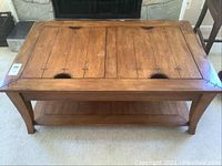 Front and full view of wooden coffee table with four removable top panels and bottom shelf.