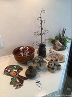 Photo showing the pottery bowls, vases, ceramic duck planter, stained glass duck, and metal vintage duck decor on a shelf.