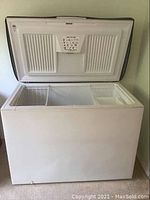 Open view of the white Kenmore chest freezer showing interior compartments and wire basket