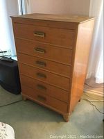 Full side view of wooden dresser showing six drawers and brass handles, condition, and stains.