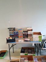 Wide view of table with stacks of DVDs and boxes
