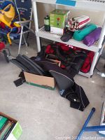 Wide view of outdoor gear items including wetsuit, flippers, backpacks, blankets, and boxed stove.