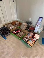 Photo showing assorted bundles of yarn, quilting squares, and hand spinning frame leaning against wall on carpet.