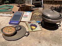 Photo of all items including silver food warmer, brass plate, framed artworks, chalkboard, round platter and lidded container