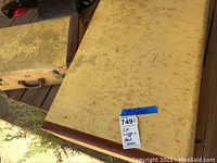 Two vintage luggage cases stacked, showing tan/beige material with brown leather trim and signs of wear and age
