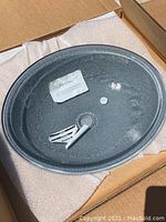 Oval Kohler glass sink placed in box with accessories inside the basin