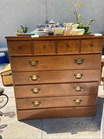 Front view of vintage dresser showing five drawers with original brass handles.