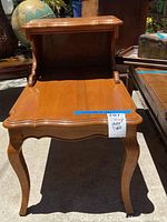 Photo of vintage wooden phone table with curved legs and scalloped edges, top and lower shelves shown from front angle.