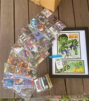 Framed Incredible Hulk comic art and collectible cards on deck box