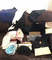 Wide view of all vintage accessories on couch, showing handbags, gloves, coin purses, and handkerchiefs