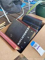 Box containing multiple hardcover yearbooks including Watchtower 1937