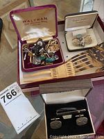 Overall lot showing multiple cufflinks in original boxes and two antique hair combs