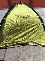 Front view of green Caribee beach shelter showing brand logo and UV protection mark.