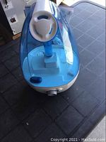 Top angled view of white and transparent blue Homedics Total Comfort humidifier showing water tank with handle and control dial on the base.