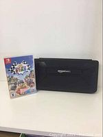 Photo showing the "Race With Ryan" Nintendo Switch game case standing upright next to a black AmazonBasics Nintendo Switch case on a white surface.