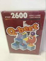Front of the Atari 2600 Q*bert game cartridge box showing the game's title, Atari 2600 branding, and Q*bert character artwork.