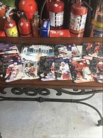 Hockey trading cards spread out on table with fire extinguishers in background