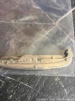 Photo of a collector's pocket knife shaped like a Venetian gondola with the inscription 'VENECIA' and visible wear.