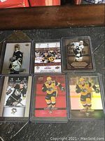 Six Sidney Crosby hockey cards arranged on a surface, each in protective sleeves, showing varied designs and backgrounds including vintage styled and action shots.