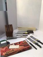 Photo showing full lot with wooden block, multiple knives, and kitchen tools on white surface