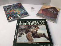 Three art books displayed on a white surface: 'Renoir Landscape Legend' with floral cover, 'Monet Impressionist Landscape' with impressionist painting cover, and 'The World of Robert Bateman' featuring a squirrel on a tree in a snowy background.
