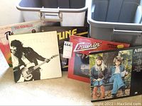 Overview photo showing seven vinyl albums including Bruce Springsteen's Born to Run, Ted Nugent's Epic (no cover), Abba Greatest Hits, The Kendalls, and others, as seen from front view, with some covers partially obscured.