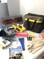 Full kit spread including the fog lights in the original box, tow rope, shovel blade, gloves, batteries, scraper, and carrying bag