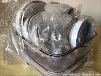 Photo of translucent 9x9x3.5 inch storage container with lid and vacuum sealer accessories in original plastic packaging.